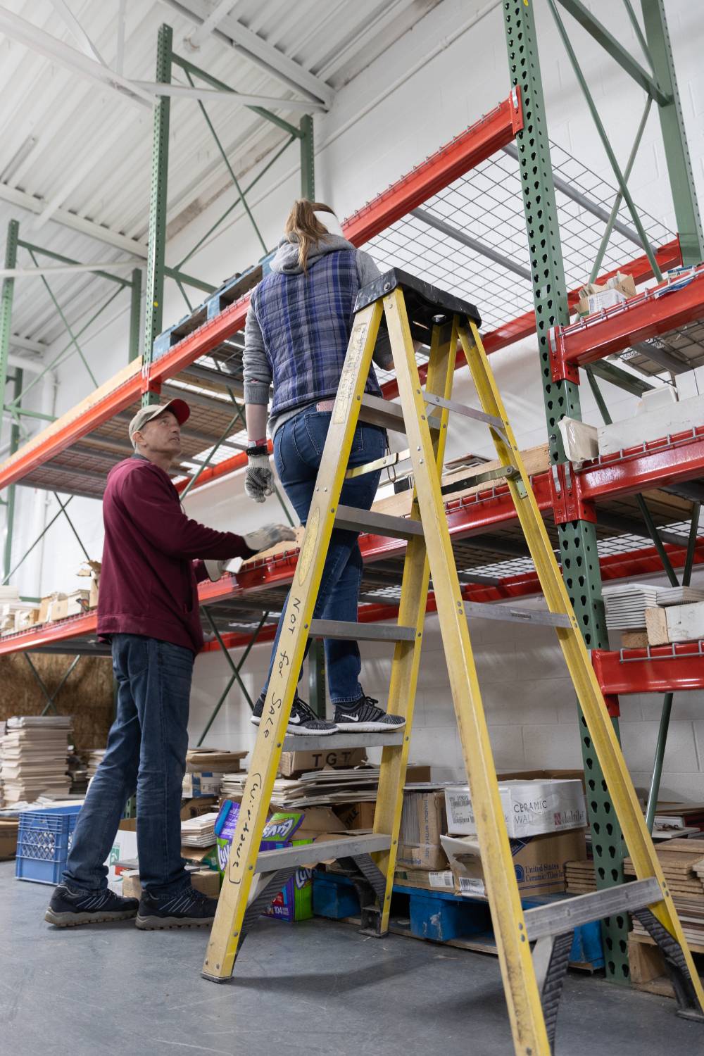 A student stands on a ladder at Restore.